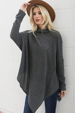 Fun asymmetrical poncho top, great with both jeans and leggings! Pair with you favorite hat or scarf and be street stylish.  Asymmetrical poncho top. Colors available charcoal gray or light gray.  60% Polyester/ 35% Rayon/ 5% Spandex. Priced at $35.00.