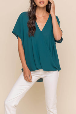 Surplice twist top 100% Polyester, loose fit,  and crossover twist front.  Available in teal and blush.  Priced at $30.00.